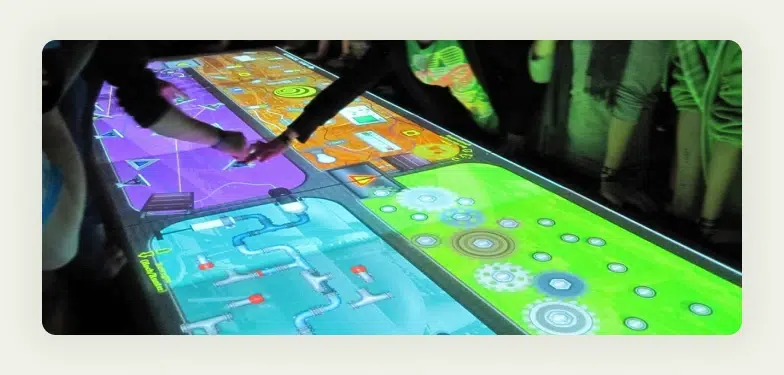 Large touchscreen display showing interactive game interface at trade show booth